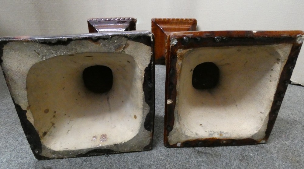 A pair of Arts and Crafts warm brown glazed earthenware plant stands featuring moulded relief scrollwork and square bases. View VII