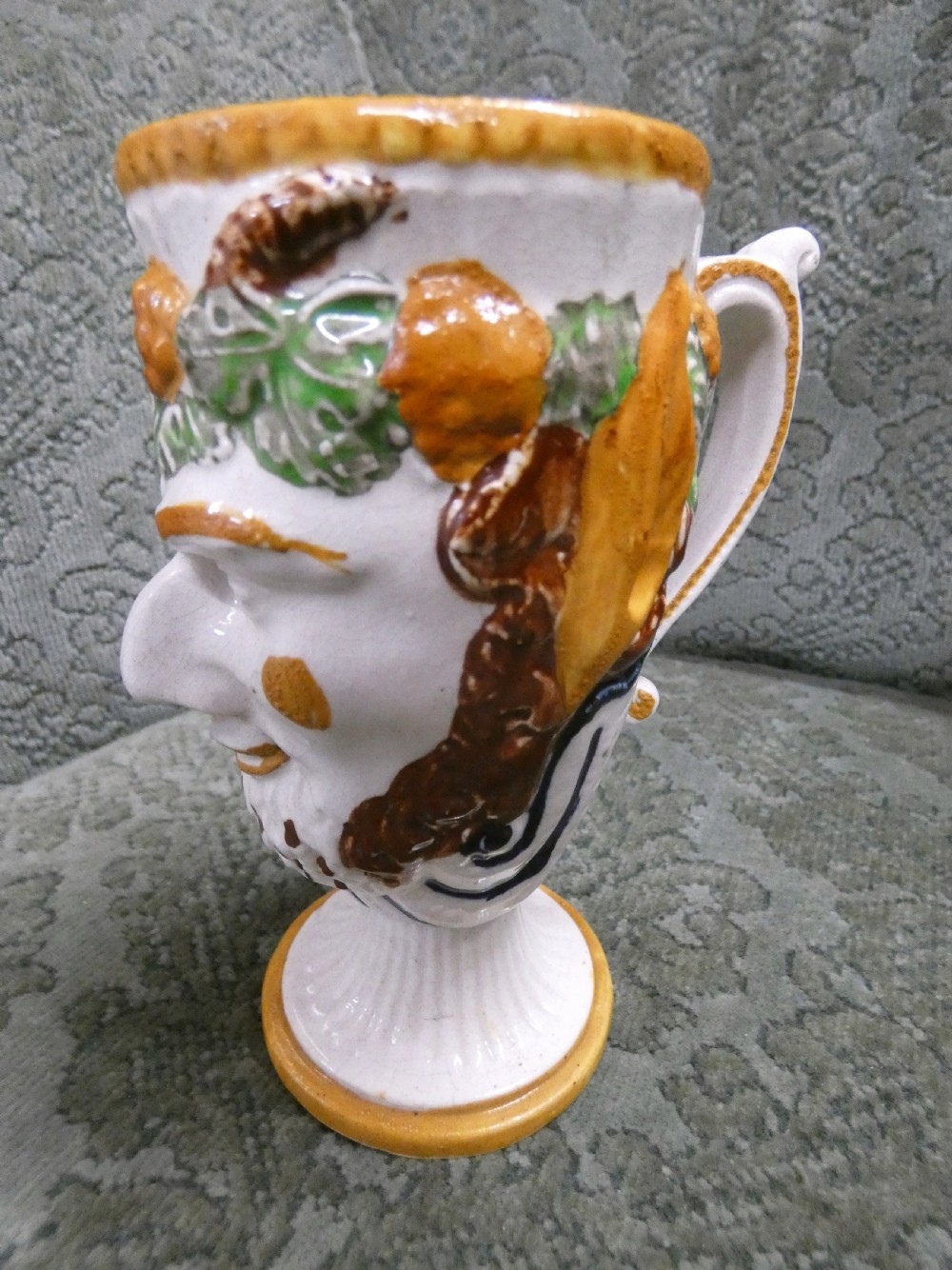A Georgian Staffordshire earthenware mug moulded in the shape of the mythological figure Bacchus with polychrome glazes and a loop handle. View VI