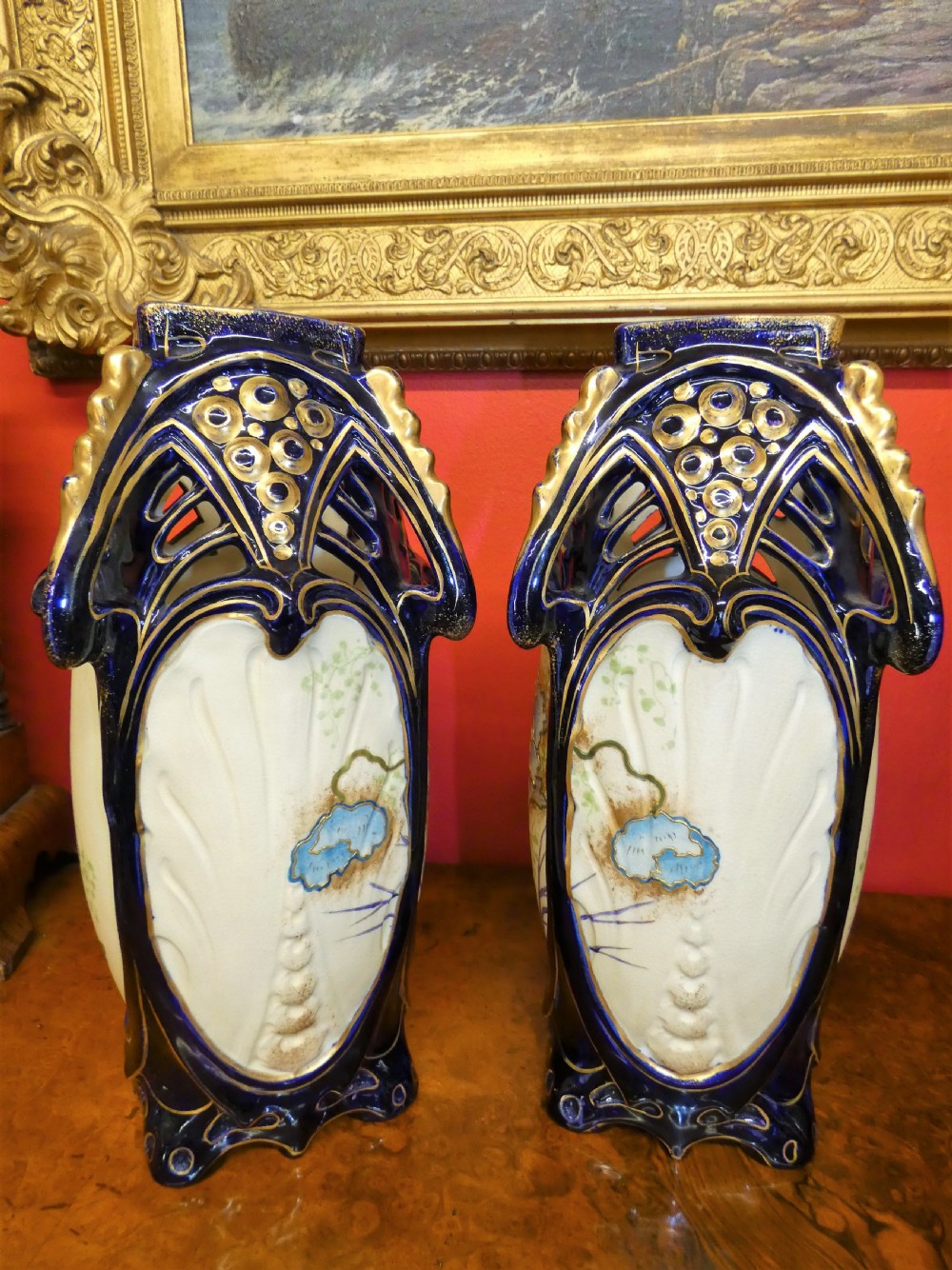 A pair of Art Nouveau ceramic vases with reticulated cobalt blue and gilt borders around hand-painted blue floral panels. View V