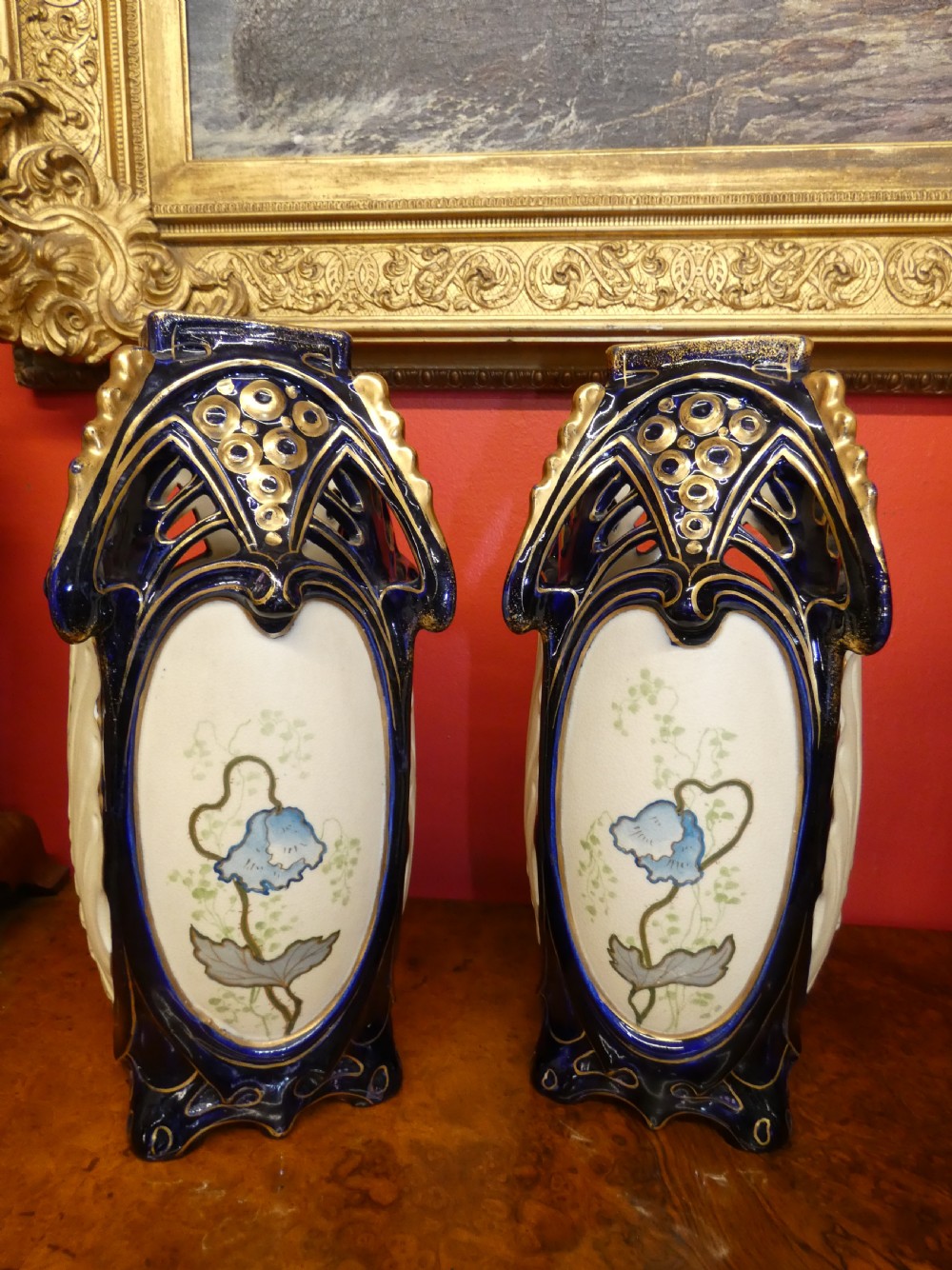 A pair of Art Nouveau ceramic vases with reticulated cobalt blue and gilt borders around hand-painted blue floral panels. View VI