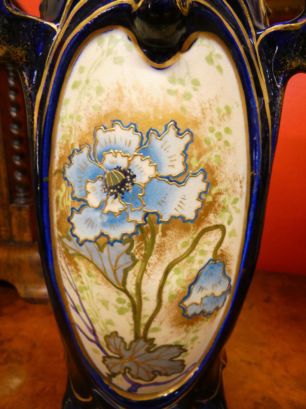A pair of Art Nouveau ceramic vases with reticulated cobalt blue and gilt borders around hand-painted blue floral panels. View IX