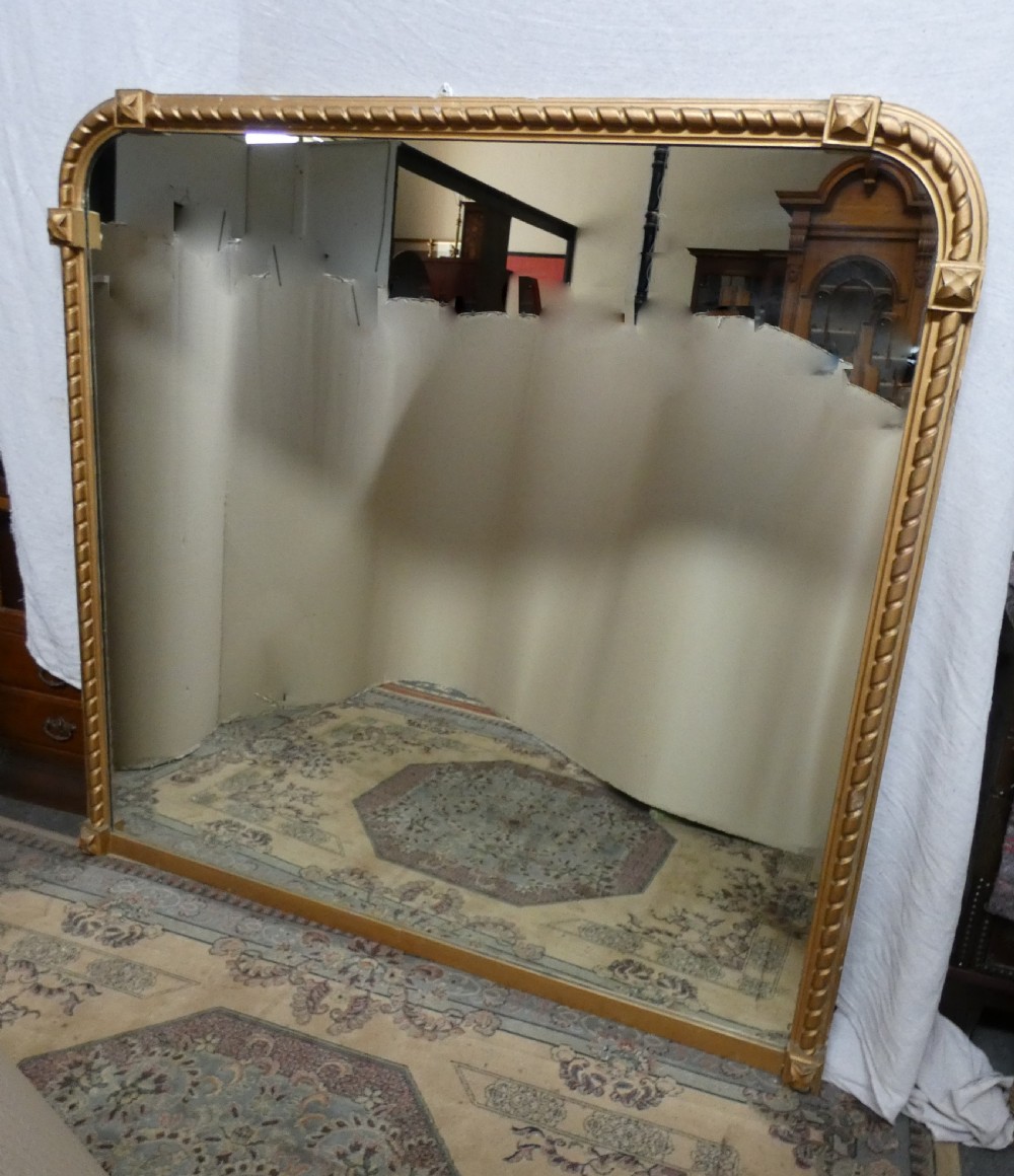 A large Victorian overmantel mirror featuring an arched gold giltwood frame with a rope-twist border and corner rosettes. View III