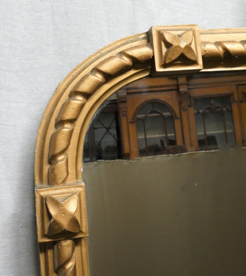 A large Victorian overmantel mirror featuring an arched gold giltwood frame with a rope-twist border and corner rosettes. View IV