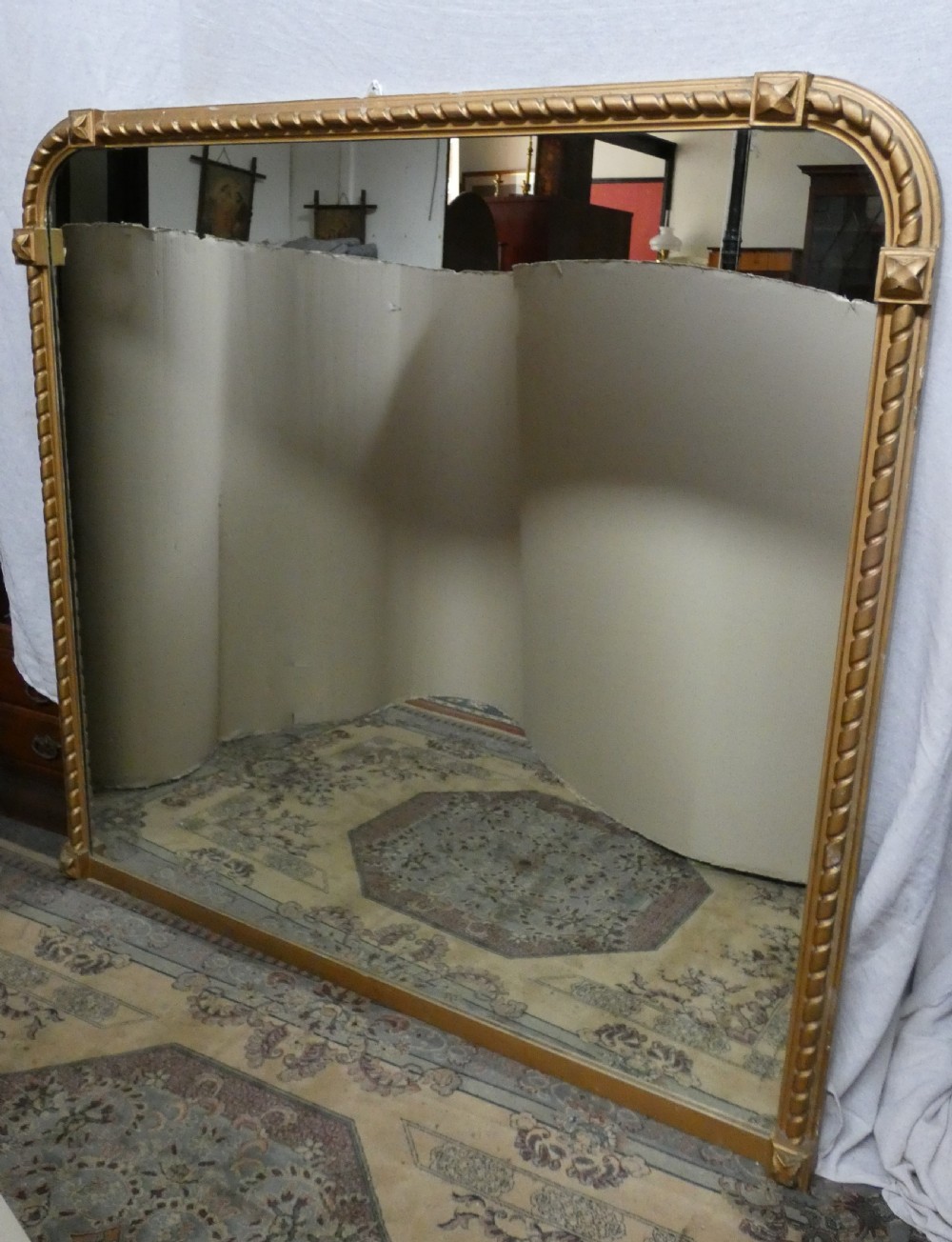 A large Victorian overmantel mirror featuring an arched gold giltwood frame with a rope-twist border and corner rosettes. View VI
