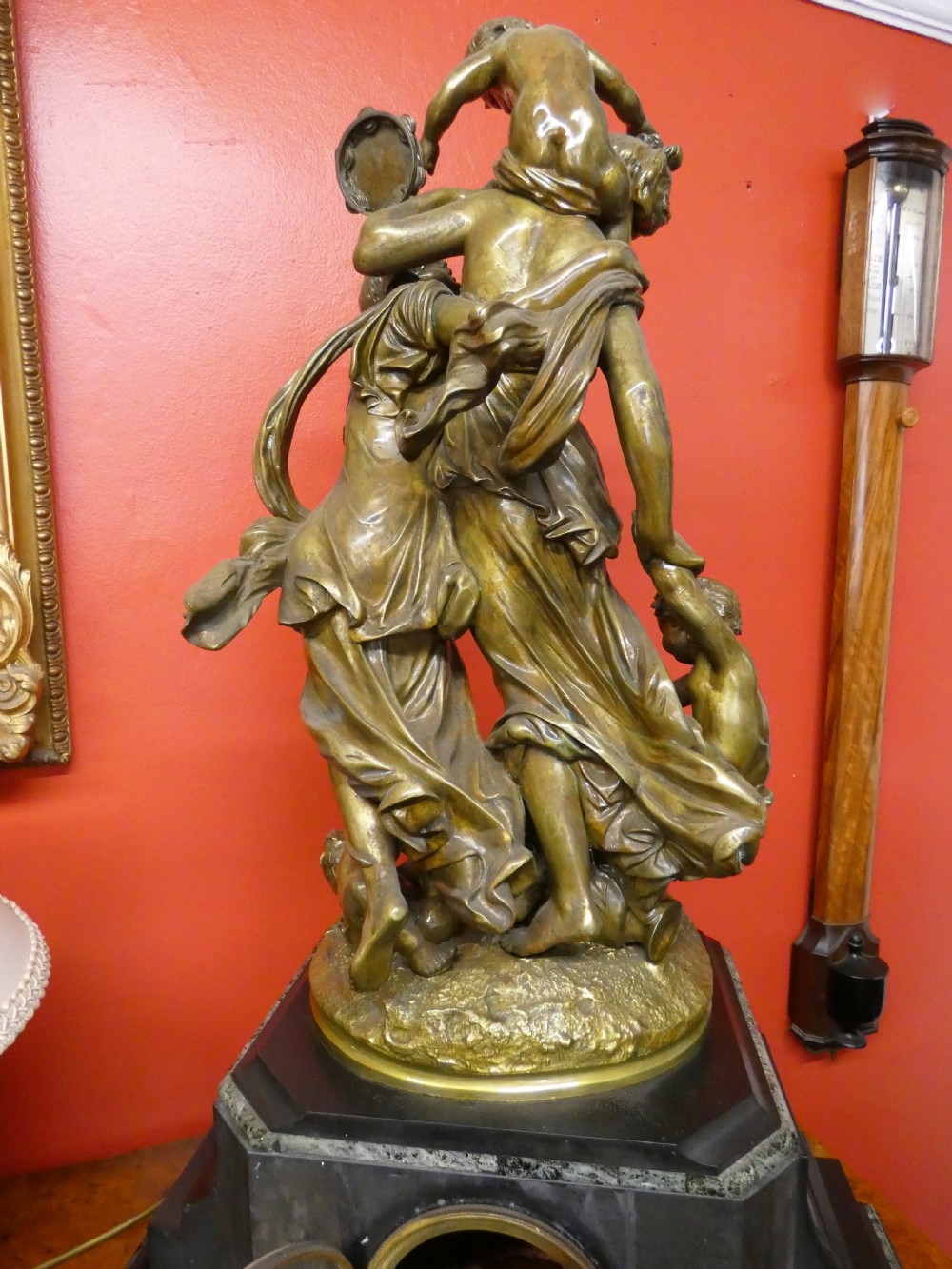 An antique French mantel clock featuring a dark marble base and a patinated bronze figural sculpture of classical figures on top. View VII