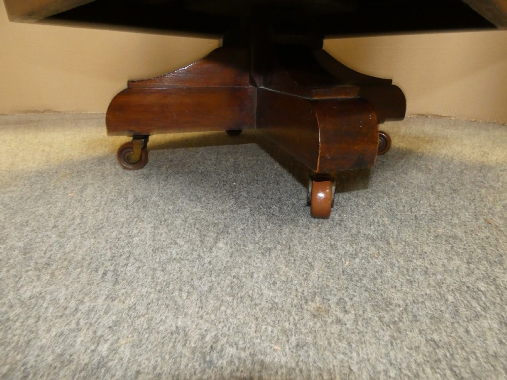 A dark polished mahogany revolving bookcase featuring vertical slatted sides with metal stud detail, multiple storage tiers, and a rotating base on castors. View VII