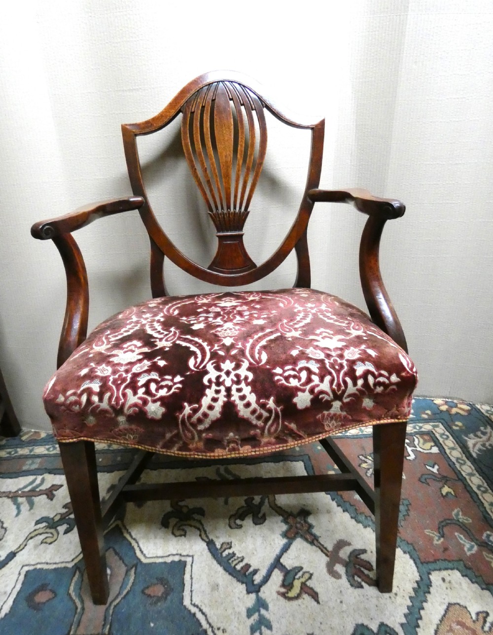 A set of six mahogany Hepplewhite dining chairs featuring carved shield backs and red patterned velvet upholstered seats. View III