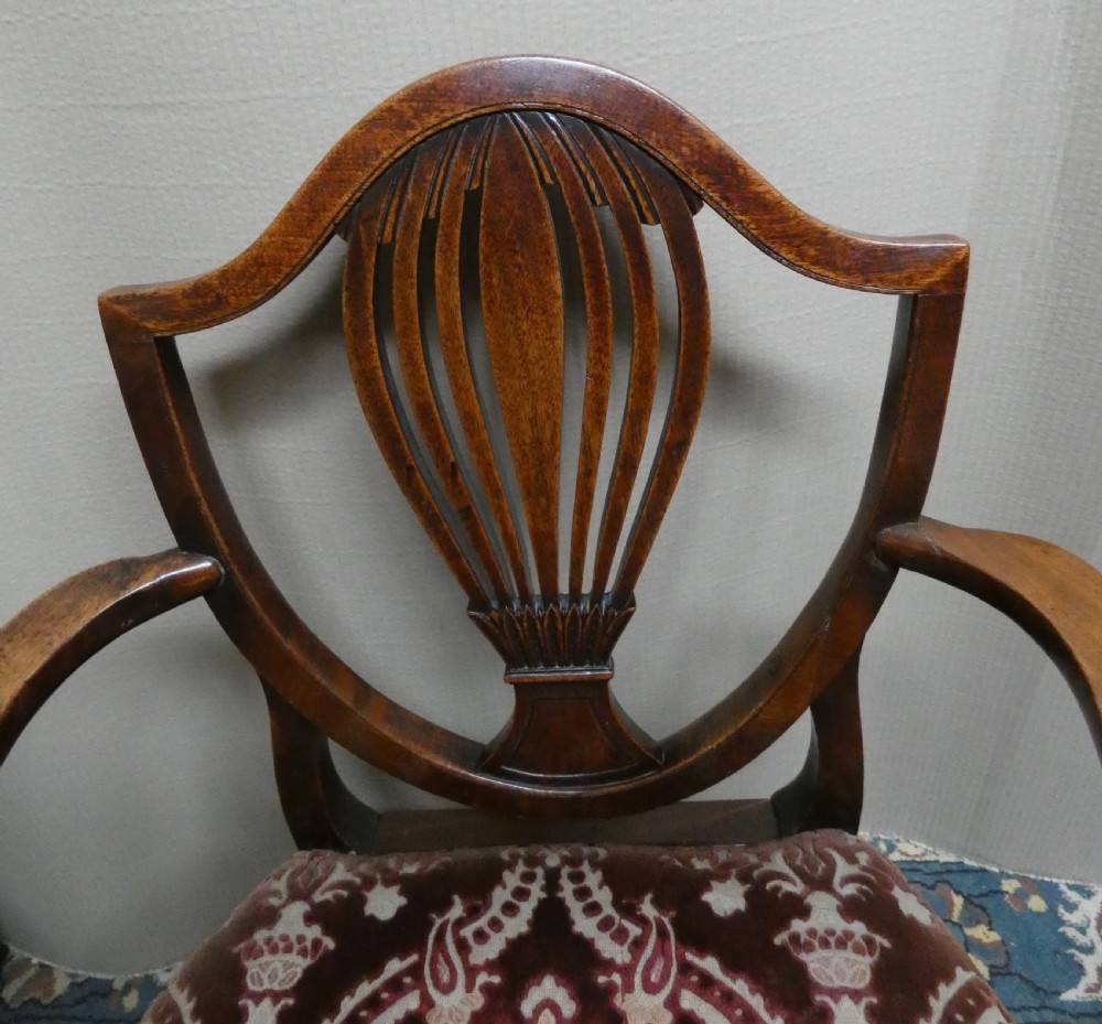 A set of six mahogany Hepplewhite dining chairs featuring carved shield backs and red patterned velvet upholstered seats. View IV