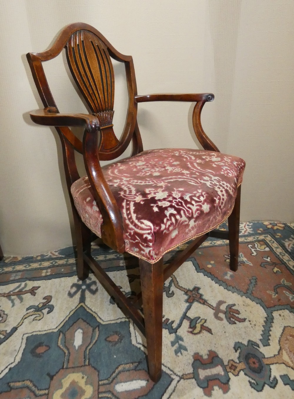 A set of six mahogany Hepplewhite dining chairs featuring carved shield backs and red patterned velvet upholstered seats. View V