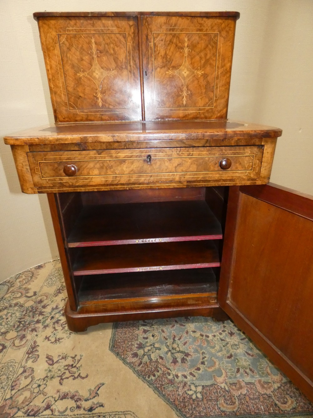 A Victorian burr walnut bonheur du jour writing desk with marquetry inlay, upper twin door cabinet, brass top gallery rail, and burgundy leather writing insert. View V