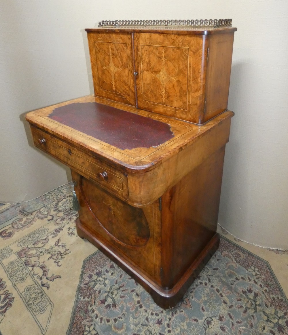 A Victorian burr walnut bonheur du jour writing desk with marquetry inlay, upper twin door cabinet, brass top gallery rail, and burgundy leather writing insert. View VI