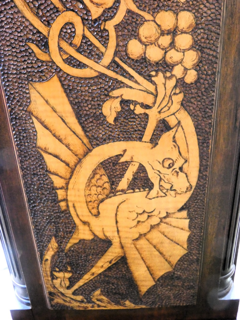 A square mahogany pedestal stand decorated with light-wood marquetry inlays featuring scrollwork and urn motifs on a stippled background. View VI