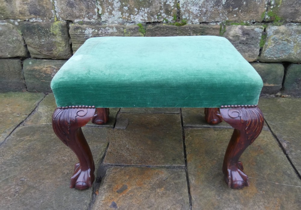 A low rectangular mahogany footstool with green velvet upholstery, studded border detail, and carved cabriole legs with claw and ball feet. View II