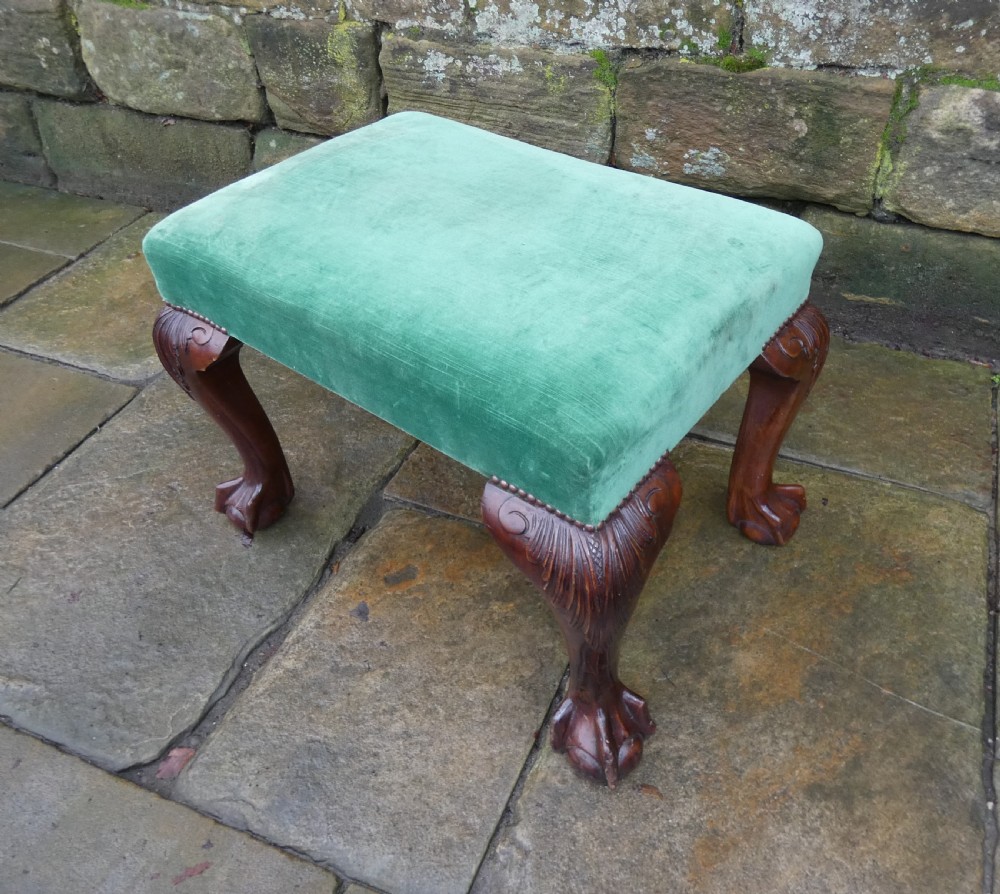 A low rectangular mahogany footstool with green velvet upholstery, studded border detail, and carved cabriole legs with claw and ball feet. View III