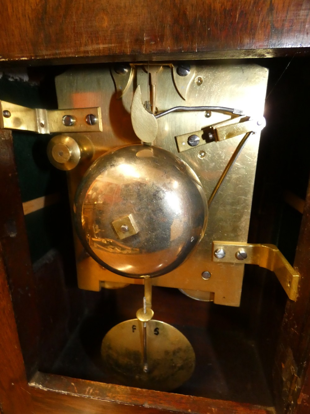 A William IV wooden bracket clock with carved foliate corner accents, brass scroll inlay, and a round dial displaying Roman numerals. View VII