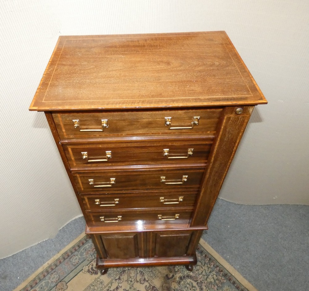 A tall antique mahogany collectors cabinet featuring five shallow upper drawers with brass handles, a hinged side locking bar, and a two-door lower cupboard resting on cabriole legs. View VIII