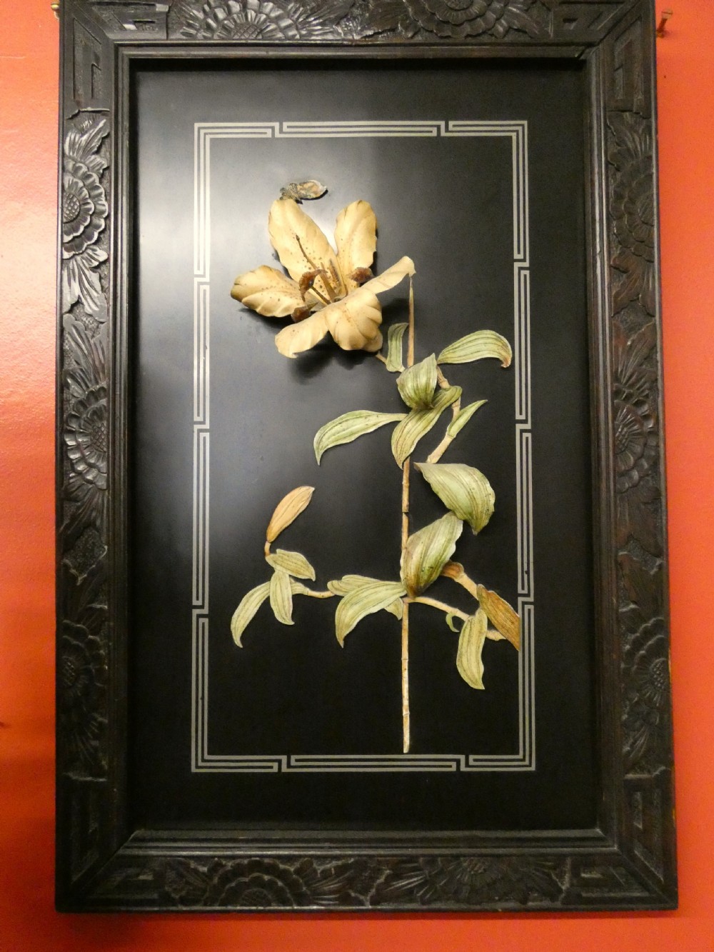 A pair of rectangular Japanese Meiji period black lacquer wall panels featuring high-relief botanical carvings of an iris and a lily within carved wooden frames. View II