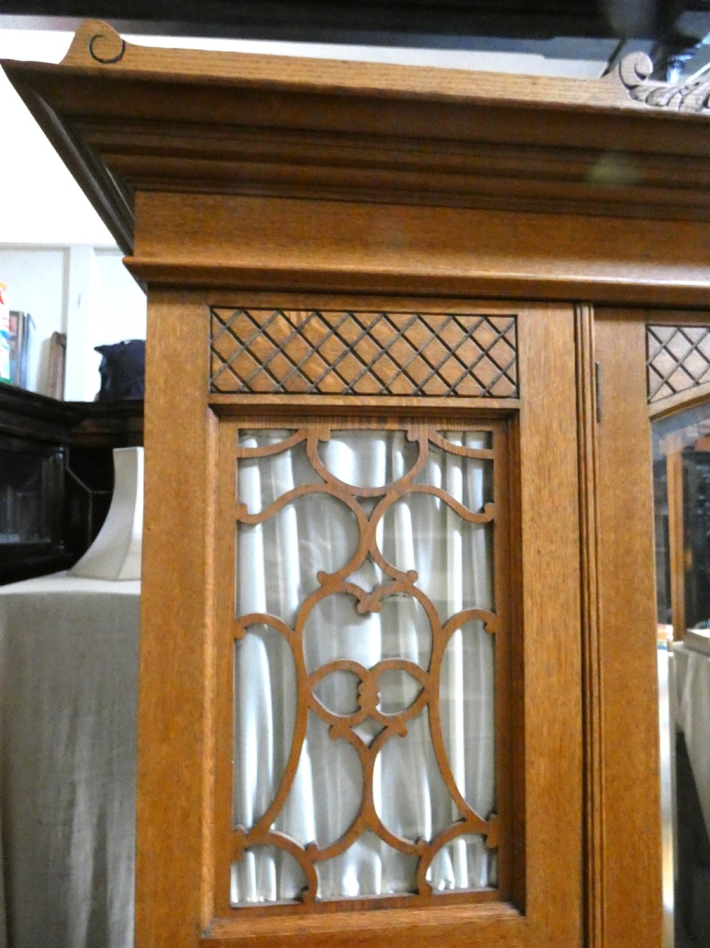 An Edwardian oak bedroom suite featuring a large three-door wardrobe with a central mirrored panel alongside a matching carved dressing table. View V