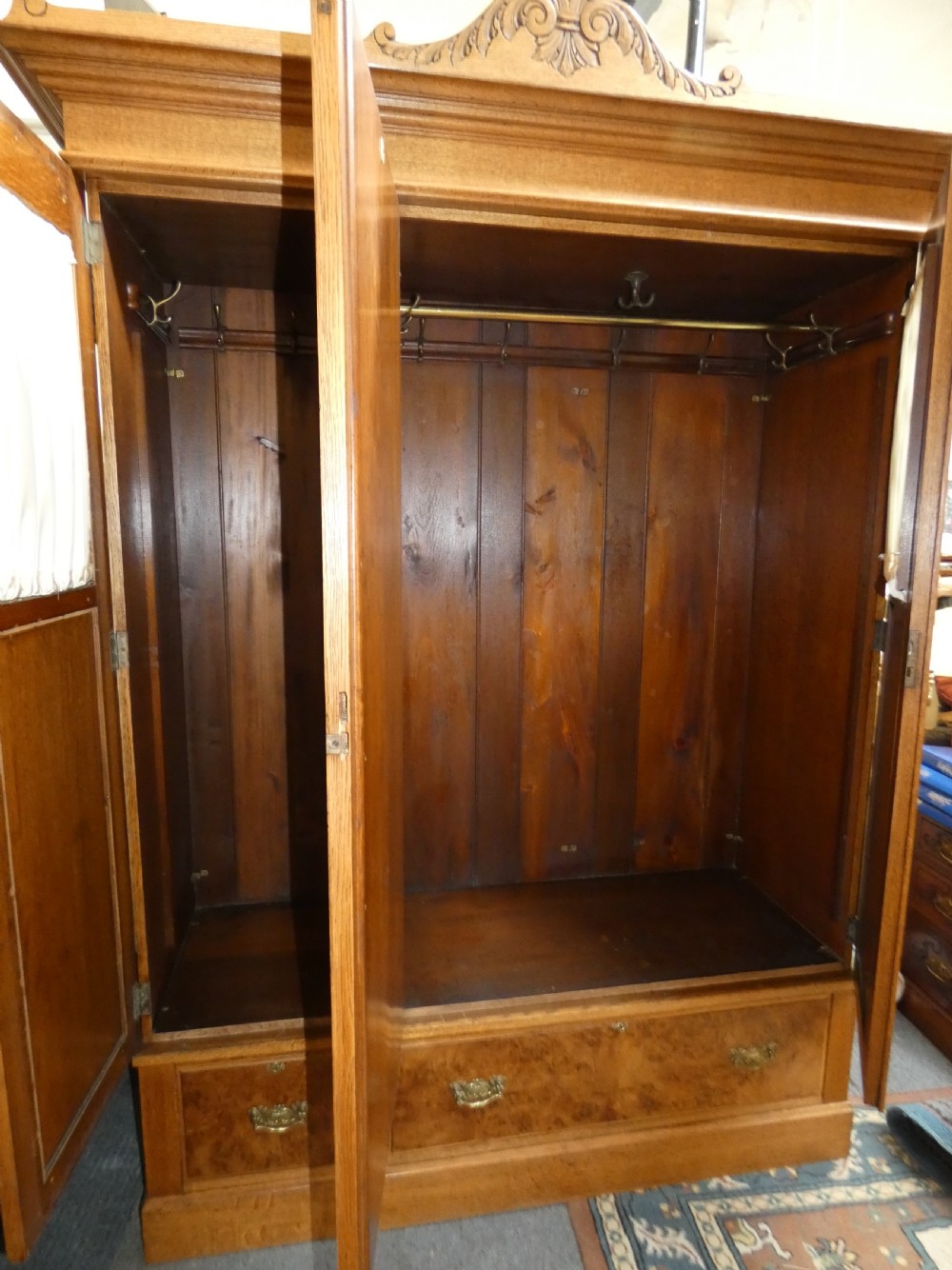 An Edwardian oak bedroom suite featuring a large three-door wardrobe with a central mirrored panel alongside a matching carved dressing table. View VI