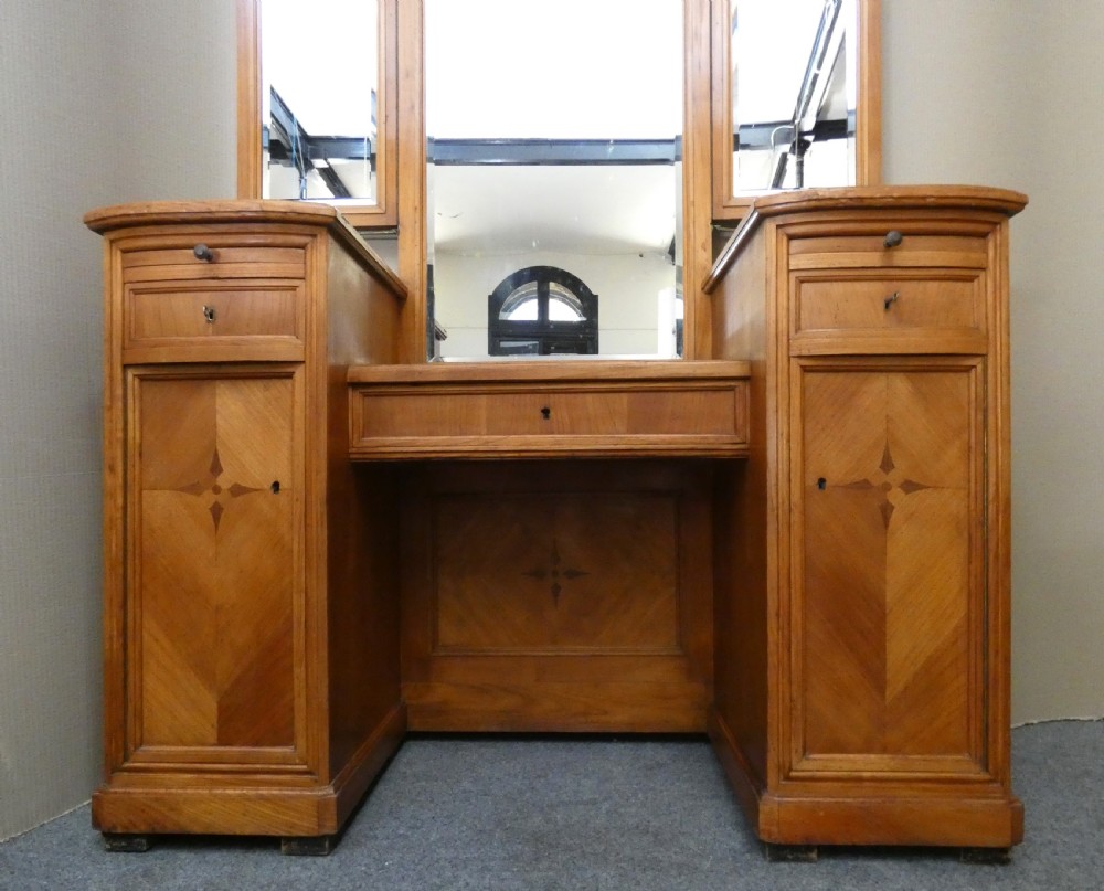 A satinwood dressing table featuring a central tall mirror flanked by two adjustable wing mirrors, twin pedestal cupboards with geometric star motif parquetry, and a central drawer. View II