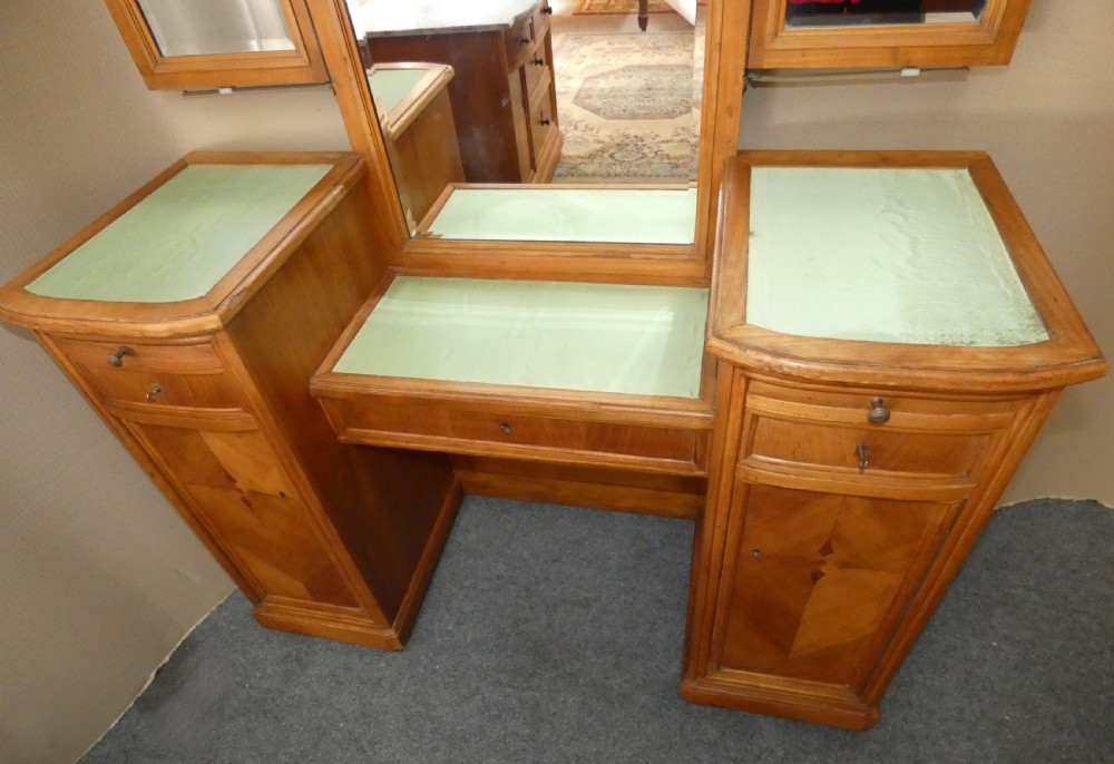 A satinwood dressing table featuring a central tall mirror flanked by two adjustable wing mirrors, twin pedestal cupboards with geometric star motif parquetry, and a central drawer. View III