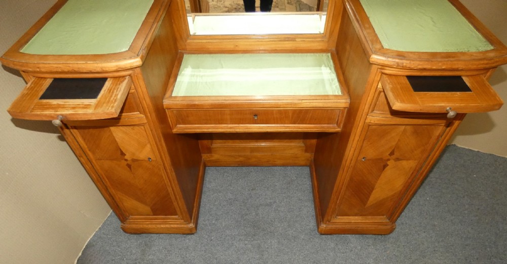 A satinwood dressing table featuring a central tall mirror flanked by two adjustable wing mirrors, twin pedestal cupboards with geometric star motif parquetry, and a central drawer. View V