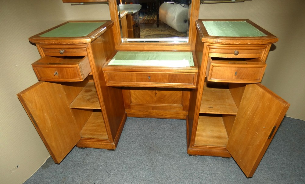 A satinwood dressing table featuring a central tall mirror flanked by two adjustable wing mirrors, twin pedestal cupboards with geometric star motif parquetry, and a central drawer. View VI