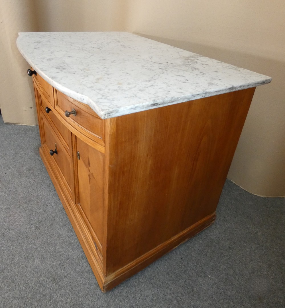 A 19th-century timber washstand featuring a white marble top, three drawers with turned knobs, and a side cupboard door with geometric parquetry inlay. View III