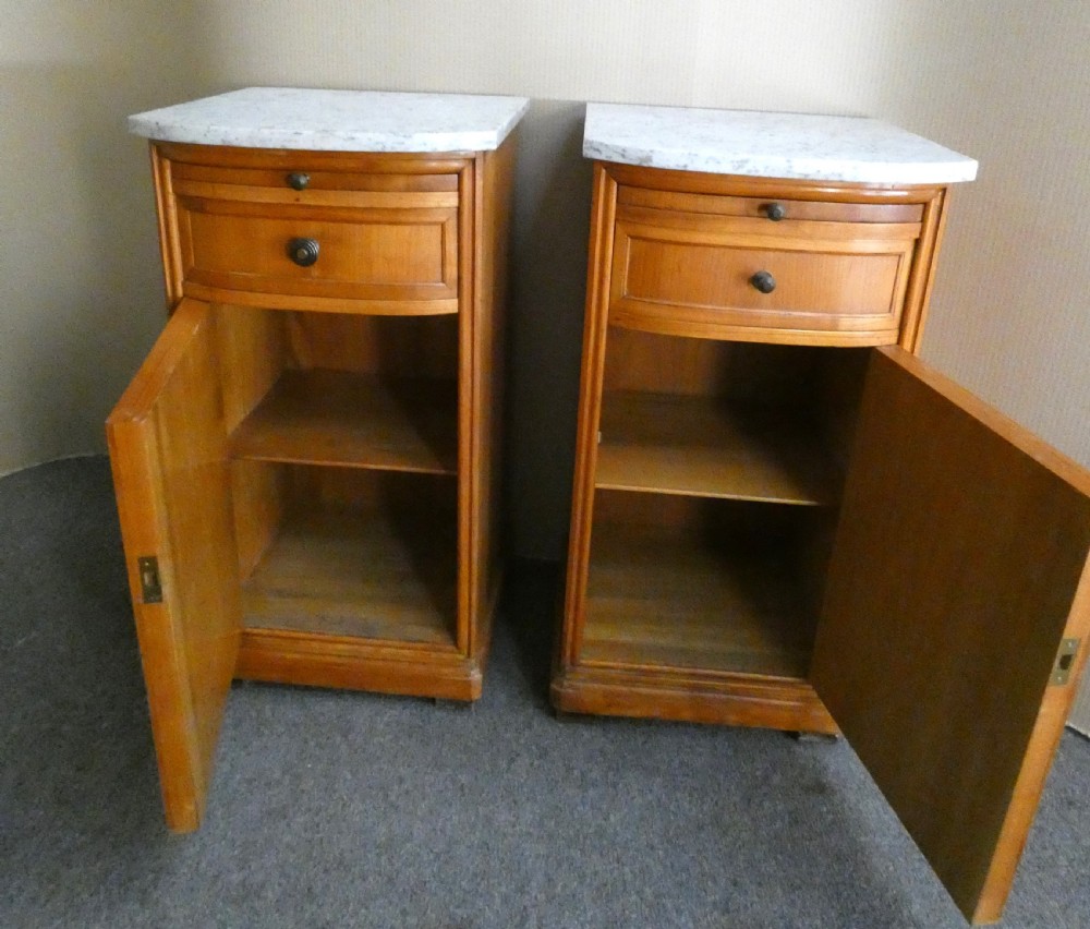 A pair of satinwood bedside cabinets with white marble tops, single drawers, pull-out slides, and marquetry inlaid cupboard doors. View VI