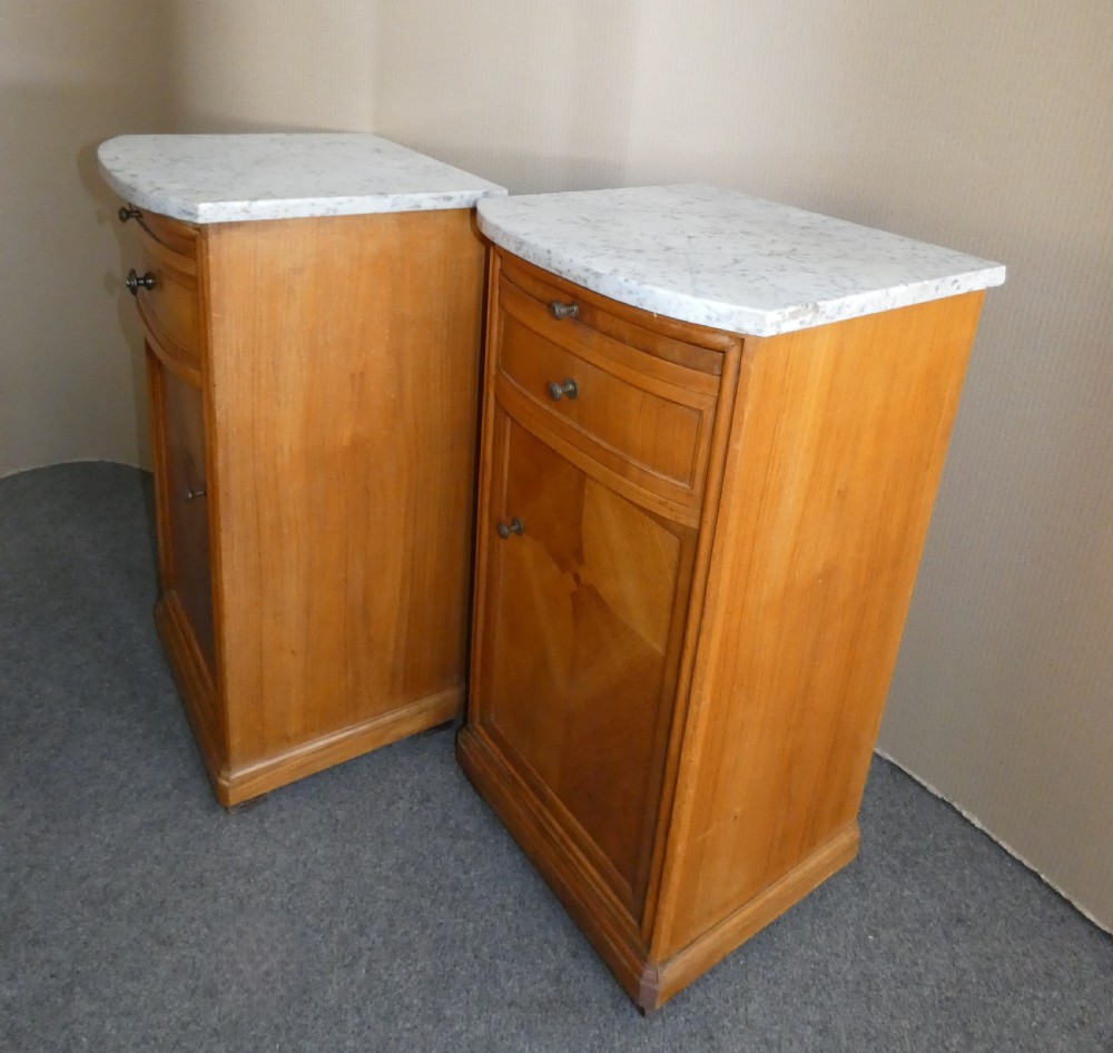 A pair of satinwood bedside cabinets with white marble tops, single drawers, pull-out slides, and marquetry inlaid cupboard doors. View VIII