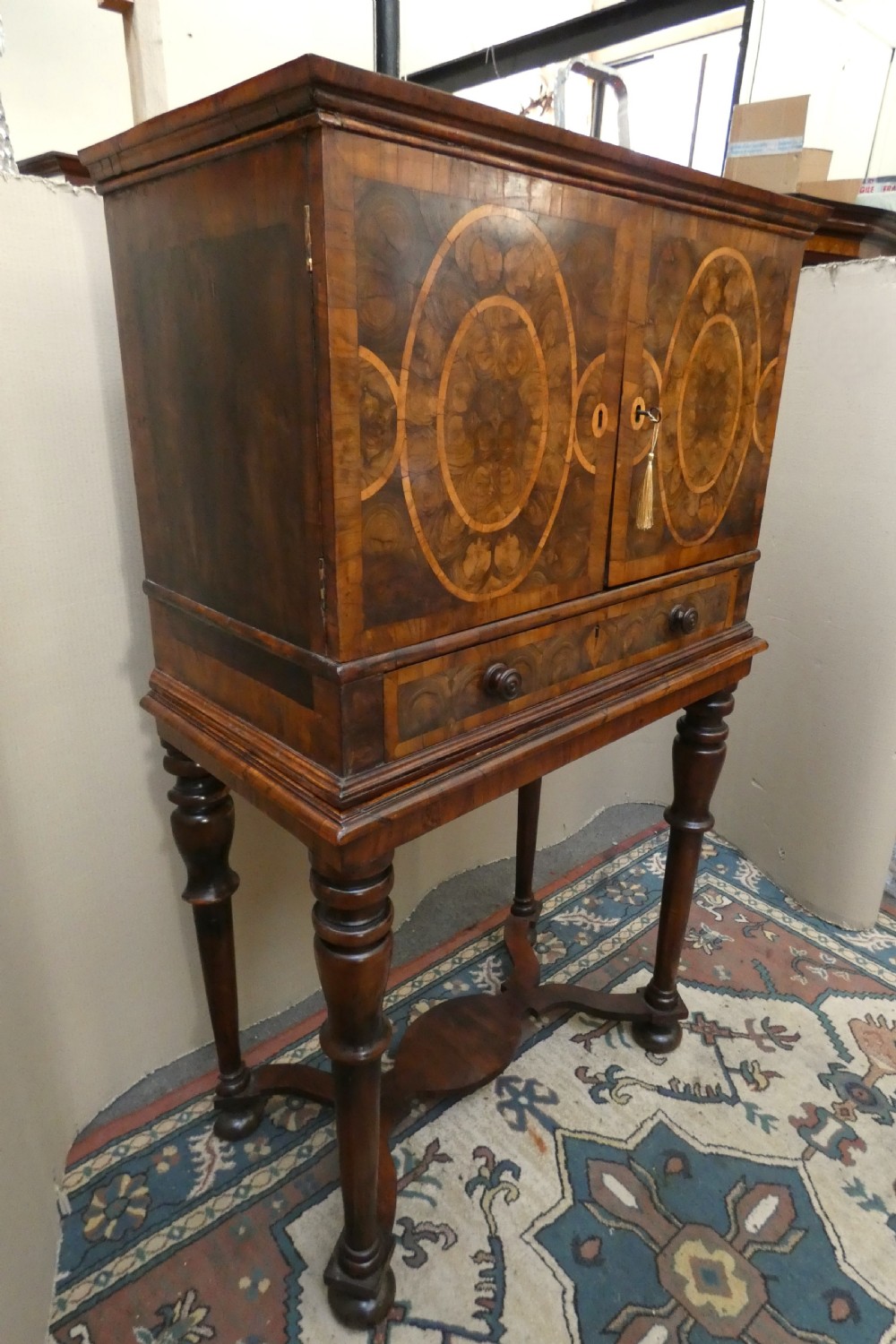 A late 17th-century olive wood cabinet on stand featuring oval oyster veneer patterns, a single drawer, and turned legs with a shaped stretcher. View III