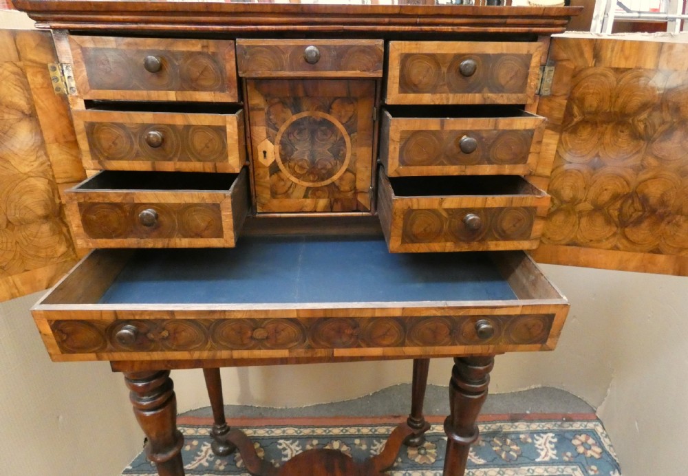 A late 17th-century olive wood cabinet on stand featuring oval oyster veneer patterns, a single drawer, and turned legs with a shaped stretcher. View VIII