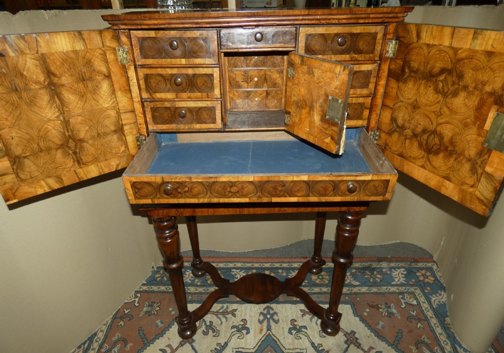A late 17th-century olive wood cabinet on stand featuring oval oyster veneer patterns, a single drawer, and turned legs with a shaped stretcher. View IX