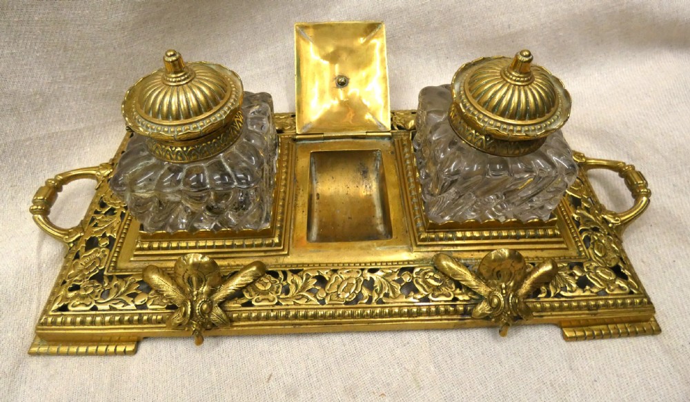 An ornate Victorian cast brass inkstand featuring twin faceted glass inkwells, a central tortoise motif, insect pen rests, and pierced scrollwork. View VI