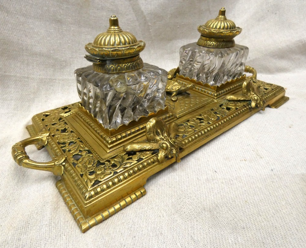 An ornate Victorian cast brass inkstand featuring twin faceted glass inkwells, a central tortoise motif, insect pen rests, and pierced scrollwork. View VII