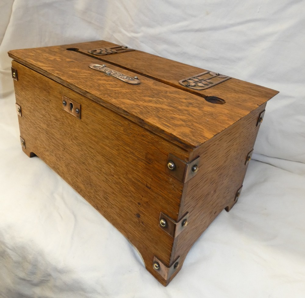 An antique Arts and Crafts solid oak letter box featuring decorative copper strap hinges, corner brackets, a top letter slot, and a central embossed copper plaque reading LETTERS. View V