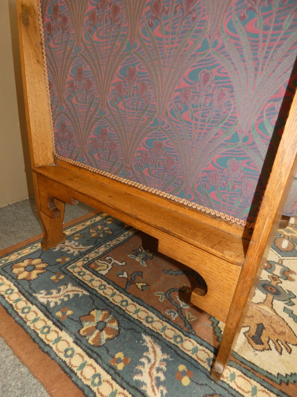 An Arts and Crafts period solid oak high-back settle featuring upholstered side panels and a cushioned seat. View IV