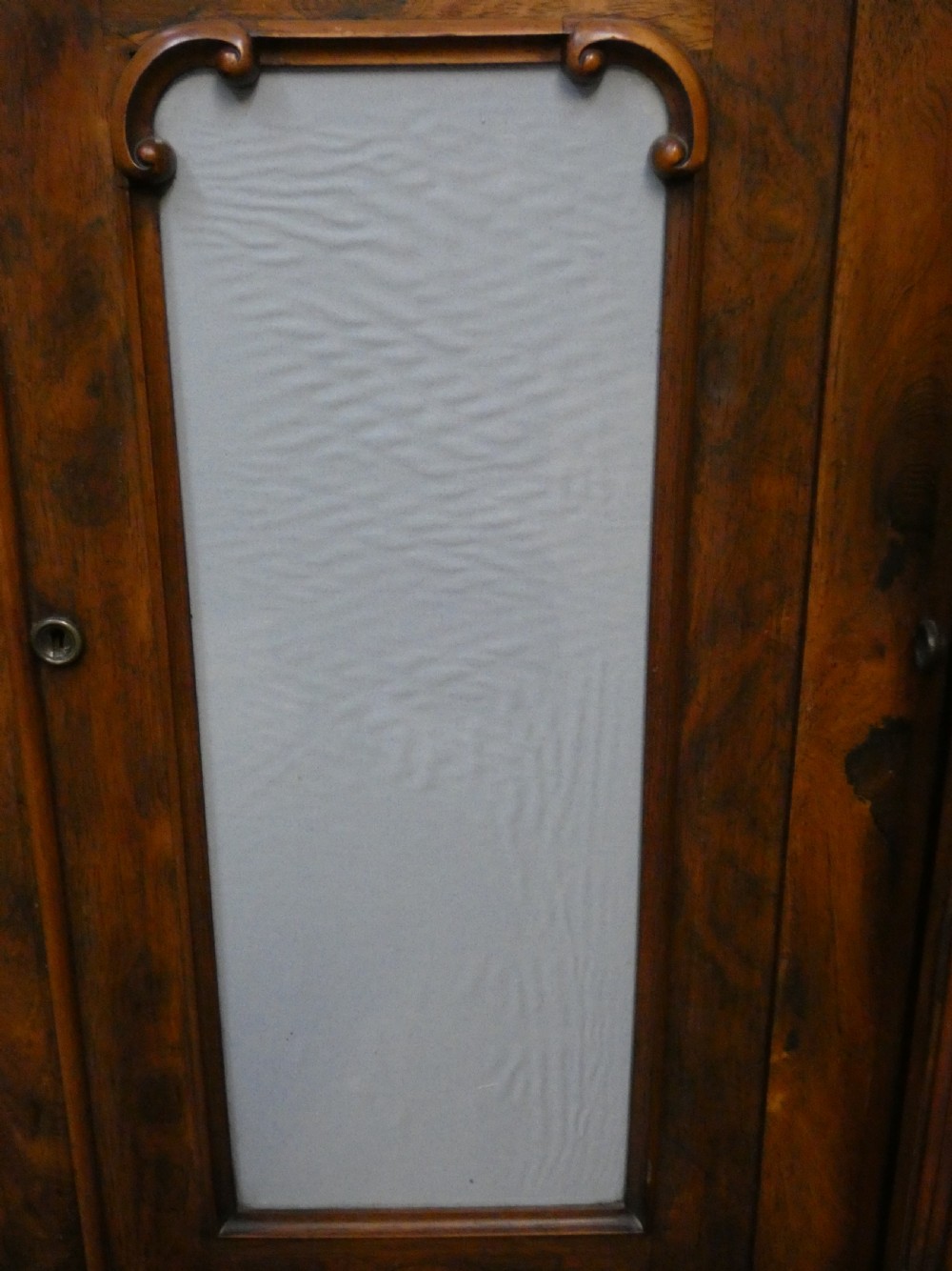 A Victorian rosewood breakfront chiffonier featuring a upper gallery shelf, central panelled cupboard doors, and outer doors with intricate pierced fretwork over light blue fabric backing. View IX