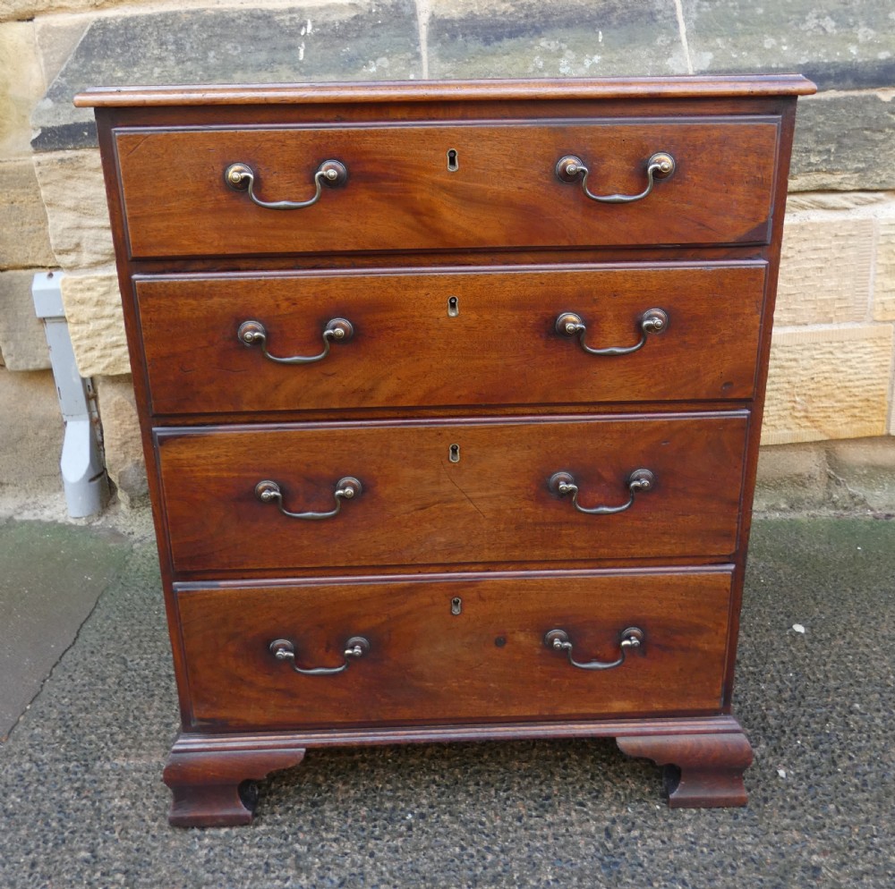 A small Georgian mahogany chest featuring four graduated drawers with brass swan-neck handles and bracket feet.