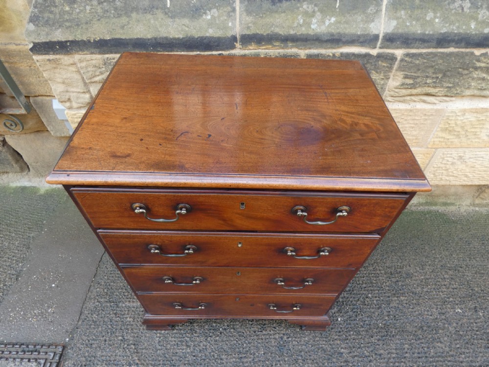 A small Georgian mahogany chest featuring four graduated drawers with brass swan-neck handles and bracket feet. View III