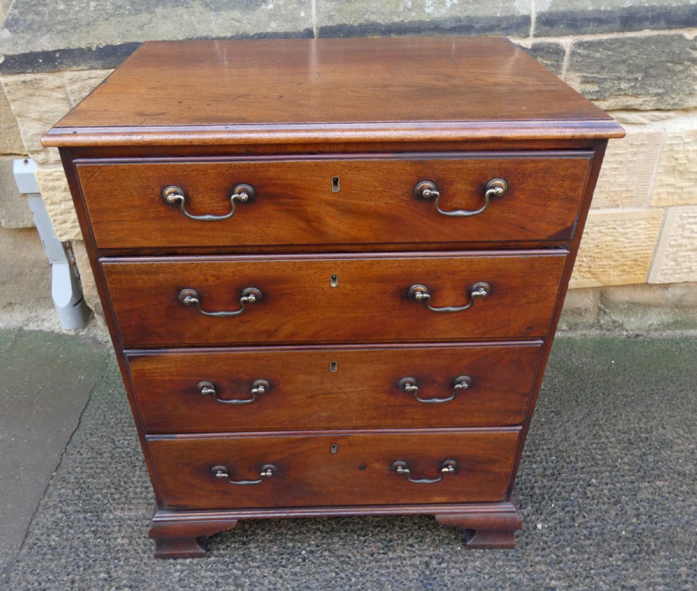 A small Georgian mahogany chest featuring four graduated drawers with brass swan-neck handles and bracket feet. View V