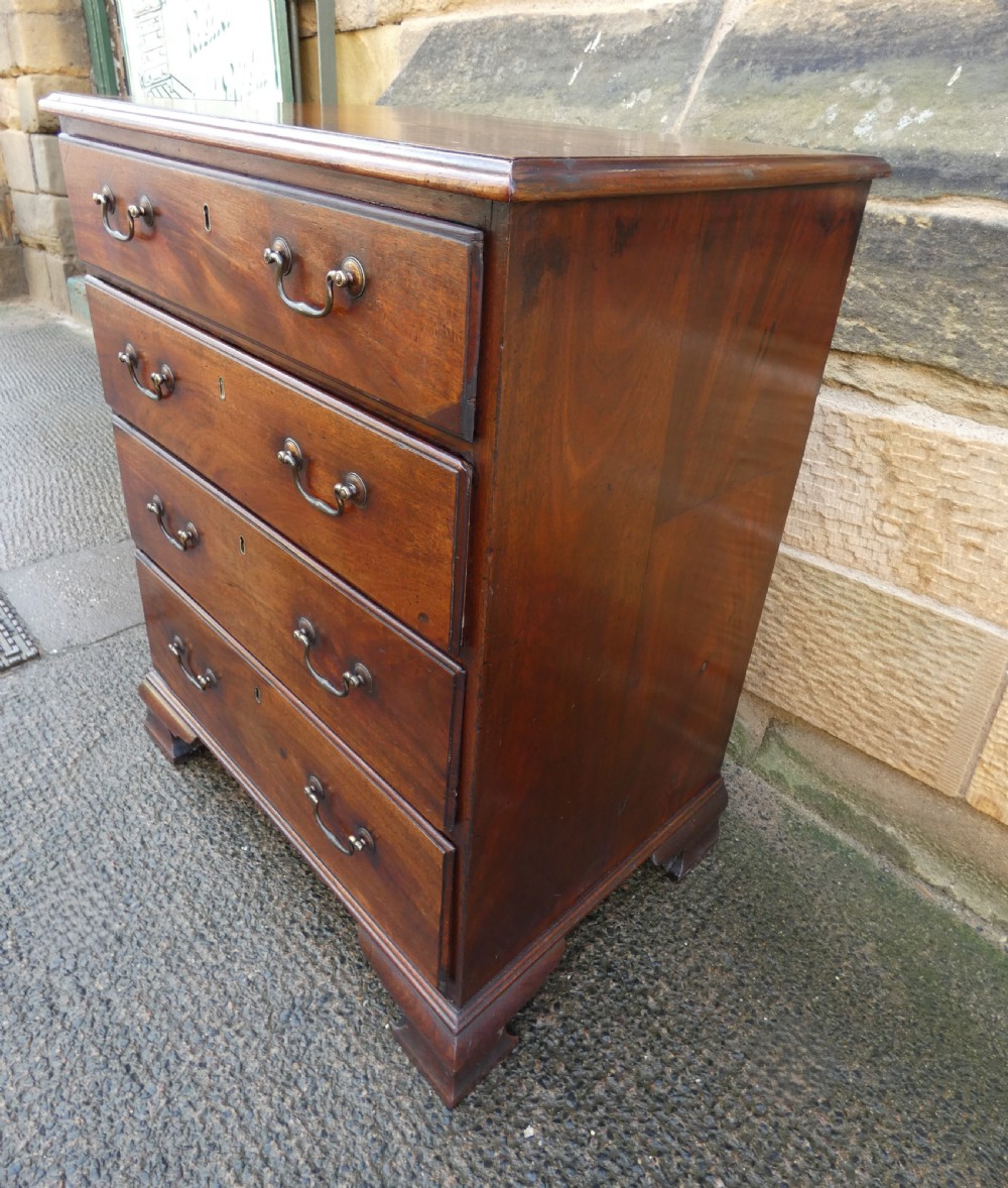 A small Georgian mahogany chest featuring four graduated drawers with brass swan-neck handles and bracket feet. View VI