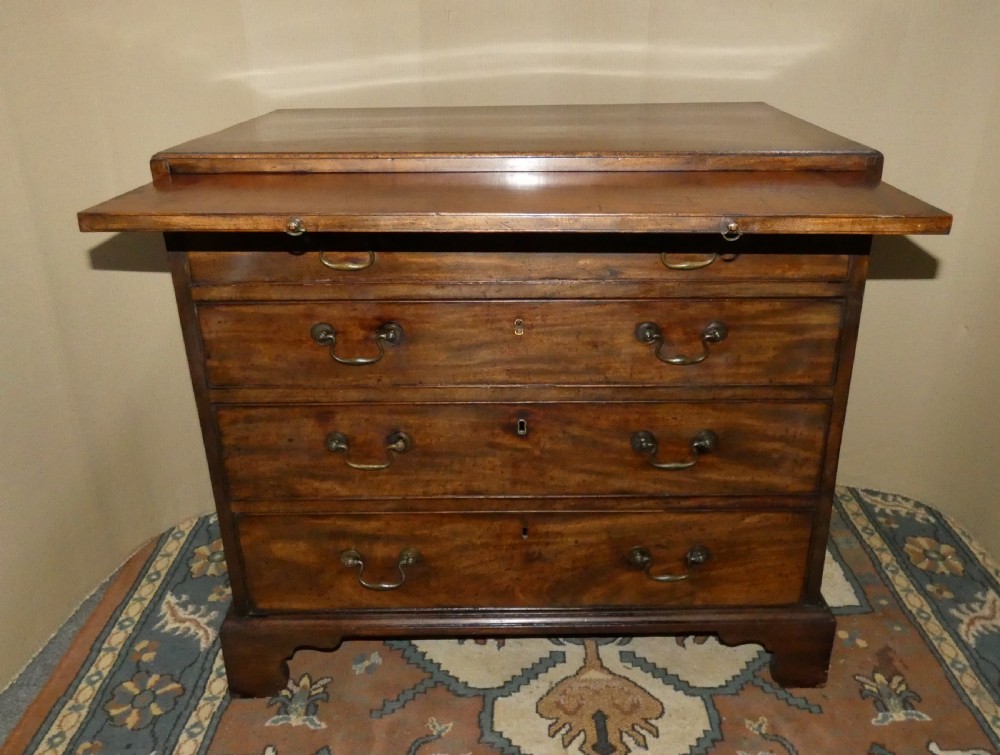 A small Georgian mahogany bachelors chest featuring four graduated drawers with brass swan-neck handles, keyholes, and bracket feet. View II