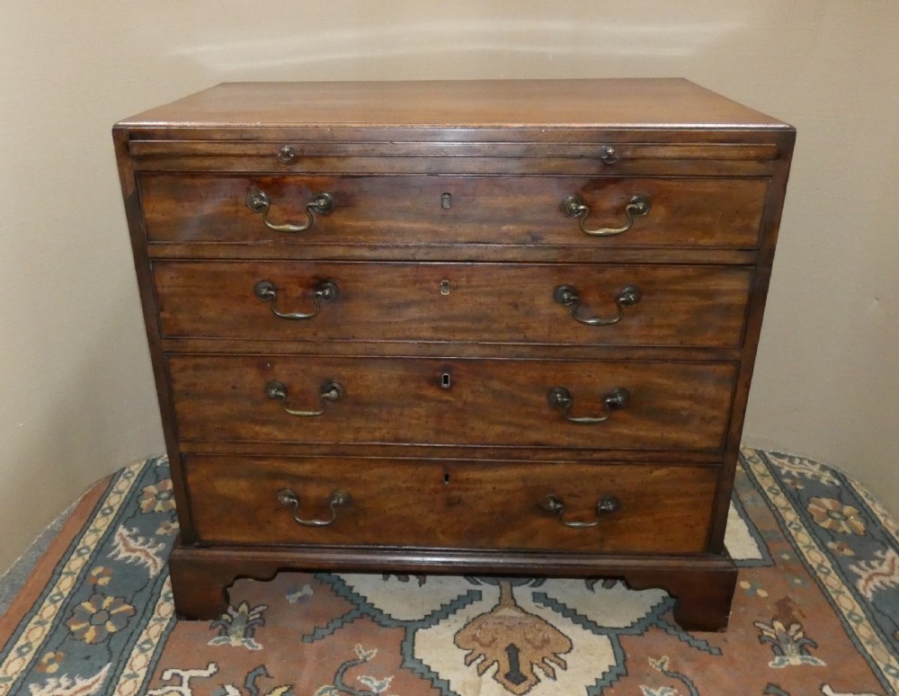 A small Georgian mahogany bachelors chest featuring four graduated drawers with brass swan-neck handles, keyholes, and bracket feet. View III