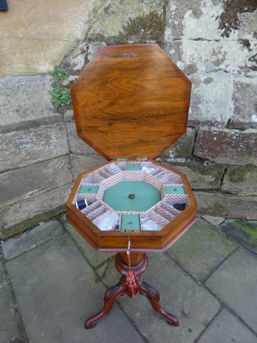 An octagonal Victorian rosewood sewing table featuring floral marquetry inlay on the top, a tapered trumpet base, and carved tripod feet. View V