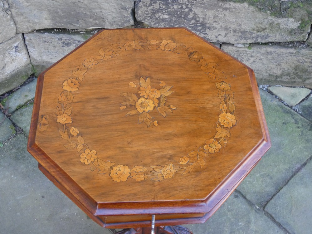 An octagonal Victorian rosewood sewing table featuring floral marquetry inlay on the top, a tapered trumpet base, and carved tripod feet. View IX
