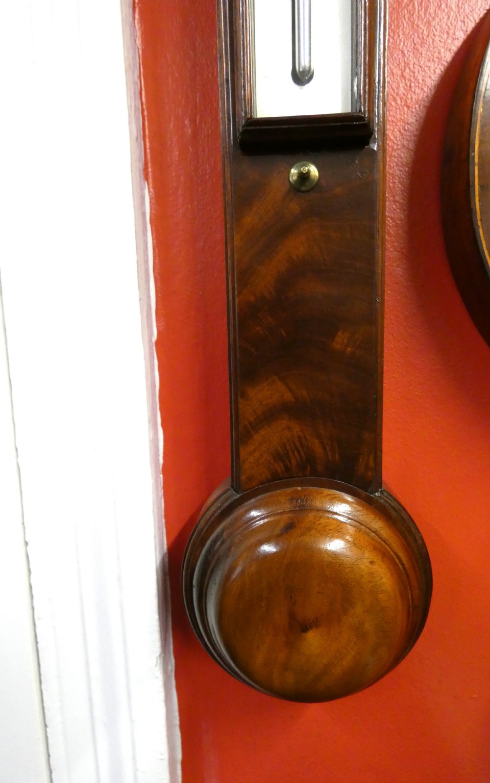 An antique Georgian mahogany stick barometer featuring a pediment with central finial, silvered register plate, integral mercury thermometer, and turned cistern cover. View III