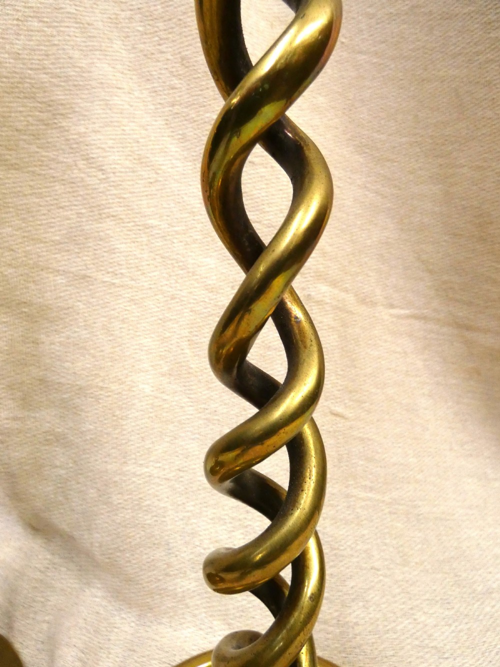 A pair of tall brass candlesticks featuring open barley twist stems and circular moulded bases. View III