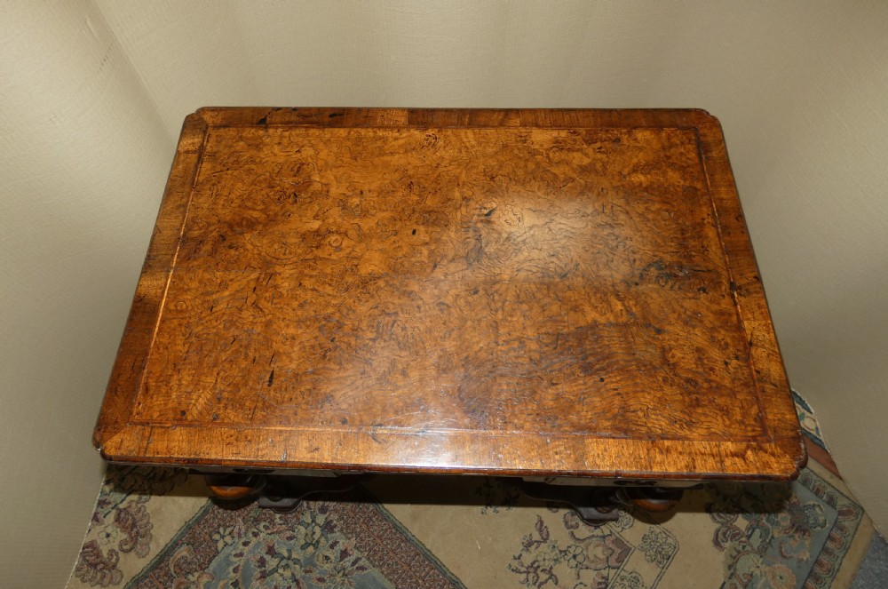 An 18th-century walnut lowboy table featuring three drawers with brass handles, turned legs, and a wavy shaped stretcher base. View III