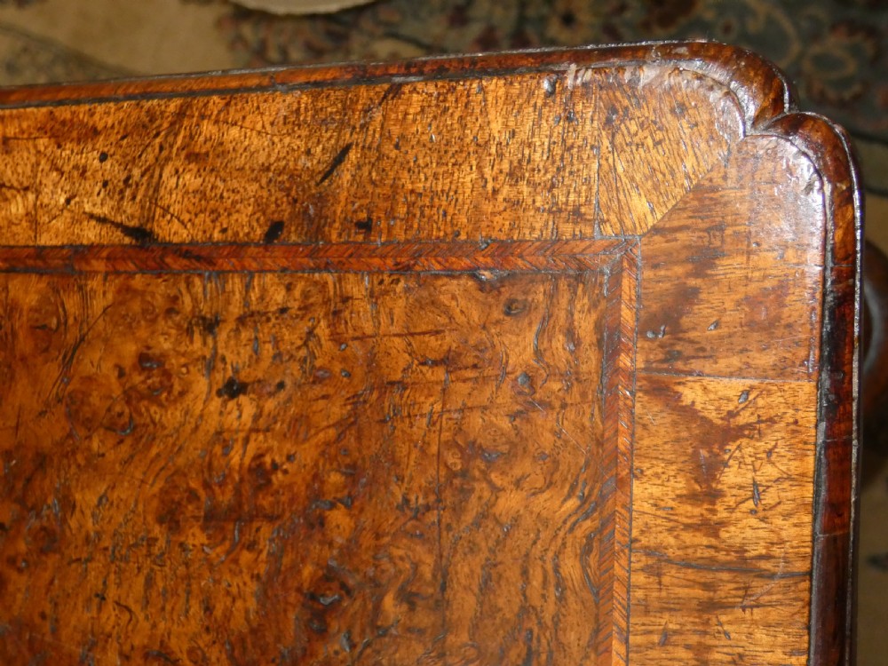 An 18th-century walnut lowboy table featuring three drawers with brass handles, turned legs, and a wavy shaped stretcher base. View X